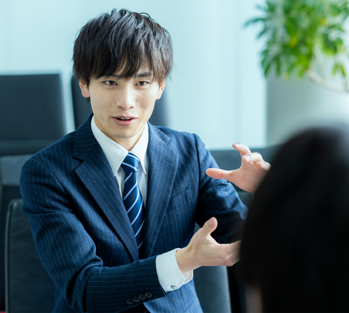 スーツ姿の営業担当者が提案をしている様子