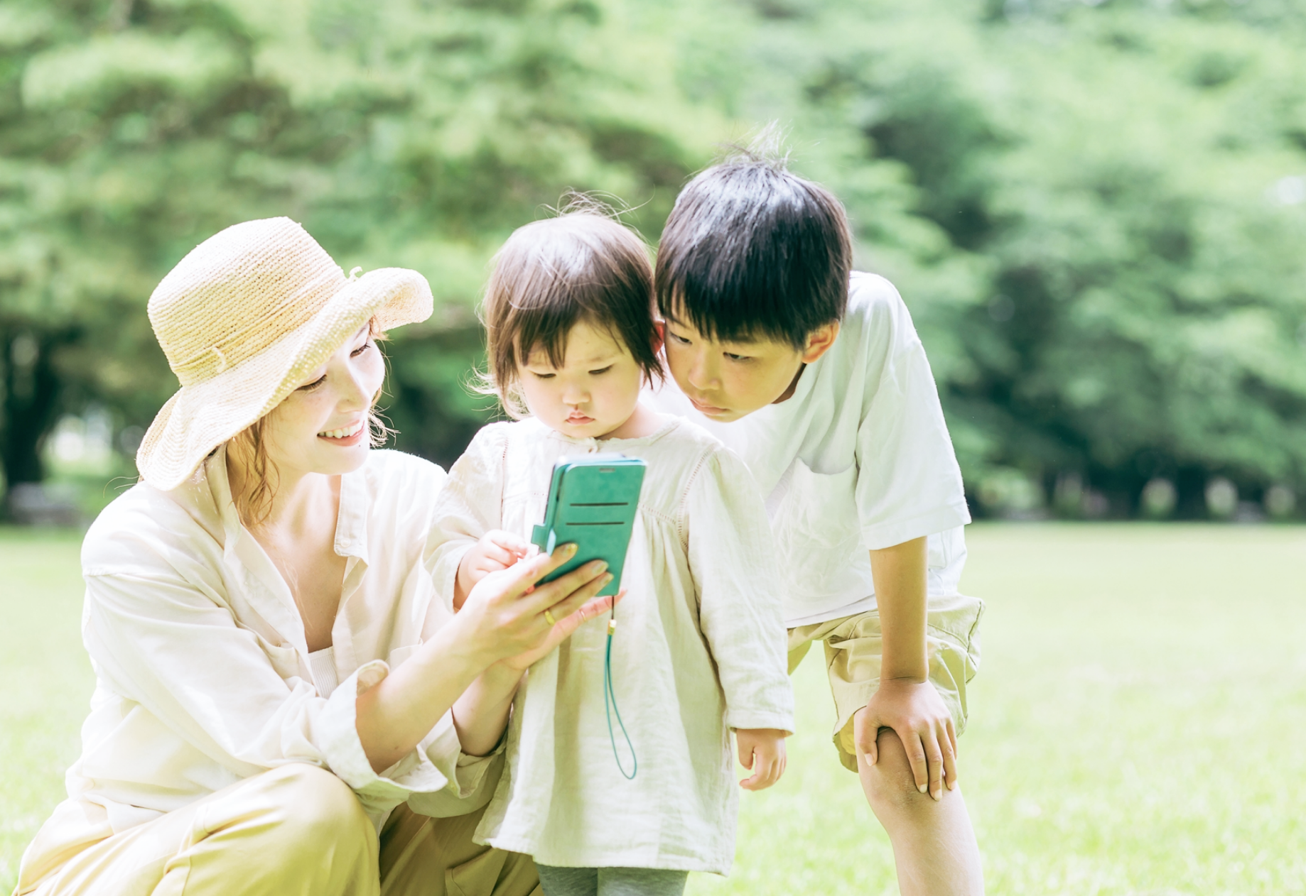 親子が屋外でタブレットを見ながら楽しんでいる様子